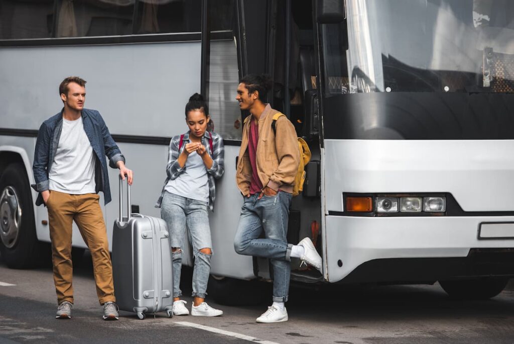 Imagem mostra jovens viajantes em rodoviária.