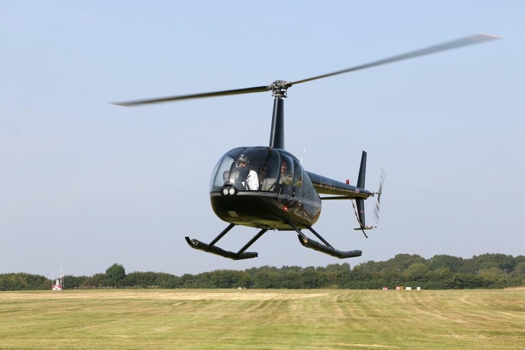 Imagem mostra helicóptero pequeno pousando em aeroporto.