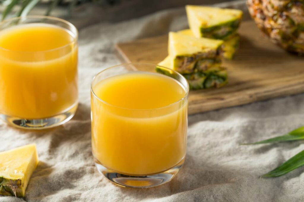 Imagem mostra um refrescante suco de abacaxi com laranja.